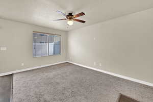 Carpeted spare room featuring a ceiling fan and a textured ceiling