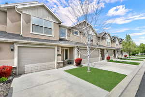 View of front of house featuring concrete driveway, stucco siding, and an attached garage