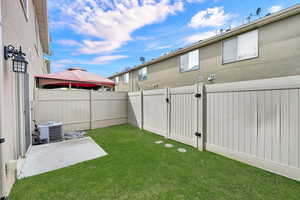 Fenced backyard featuring a patio and a gate