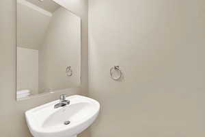 Bathroom featuring a sink and vaulted ceiling