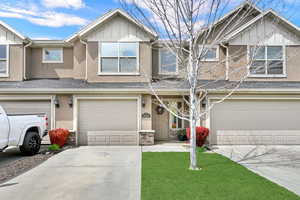 View of front of home featuring a shingled roof, stucco siding, concrete driveway, and an attached garage