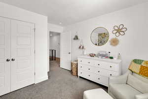 Living area featuring dark carpet and a textured ceiling