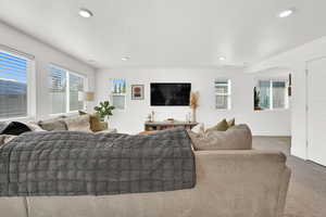 Living area featuring carpet flooring, healthy amount of natural light, recessed lighting, and a textured ceiling