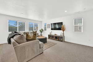 Carpeted living room with a textured ceiling and recessed lighting