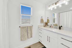 Full bath featuring a shower with curtain, vanity, and light wood-type flooring