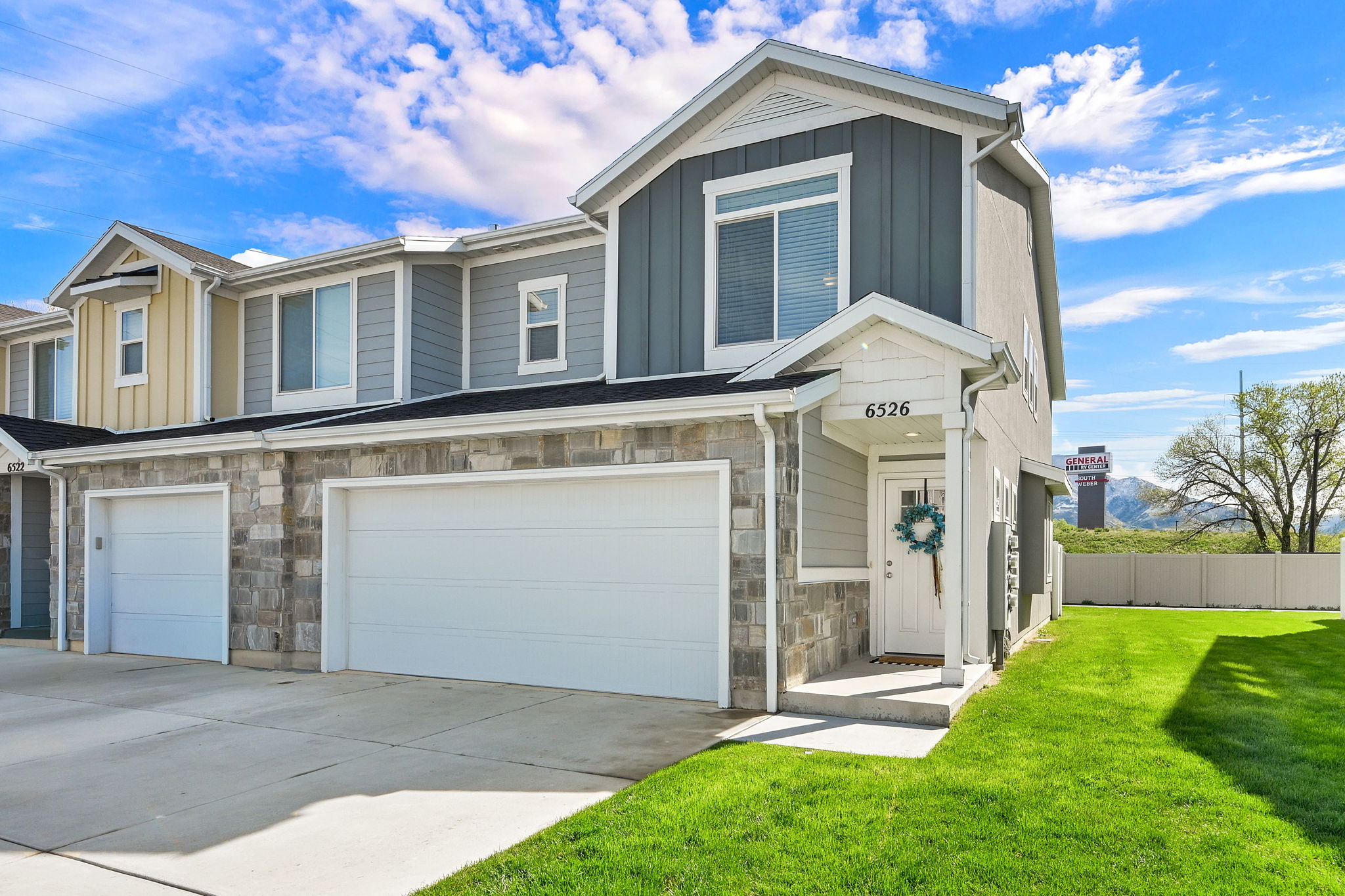 Craftsman house with stone siding, board and batten siding, a garage, and concrete driveway