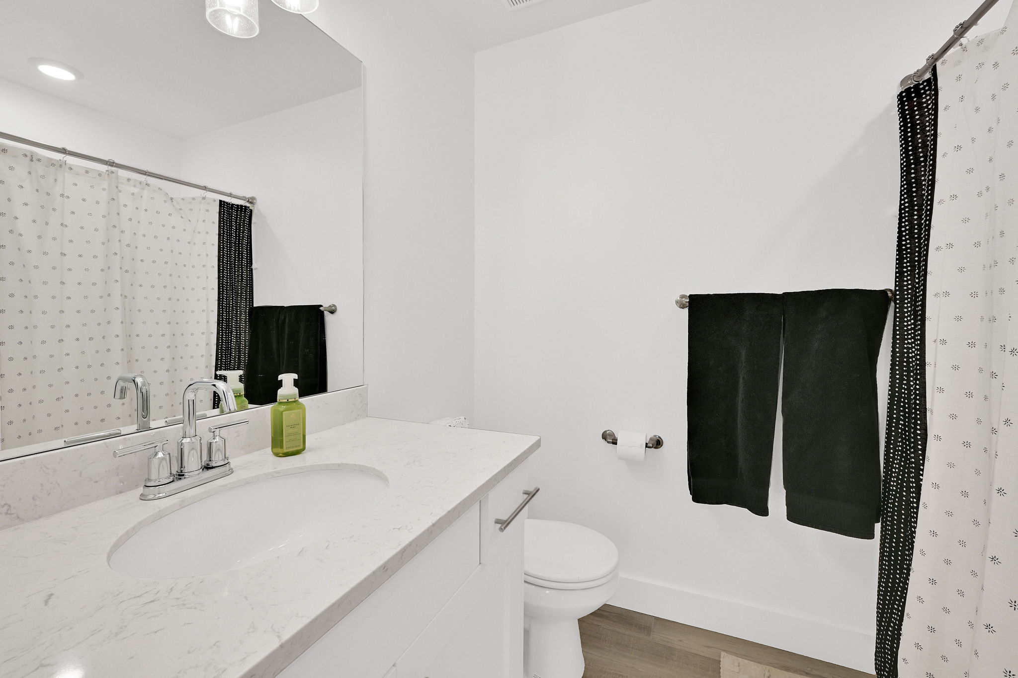 Bathroom featuring vanity, a shower with shower curtain, and light wood-style flooring