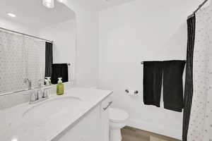 Bathroom featuring vanity, a shower with shower curtain, and light wood-style flooring
