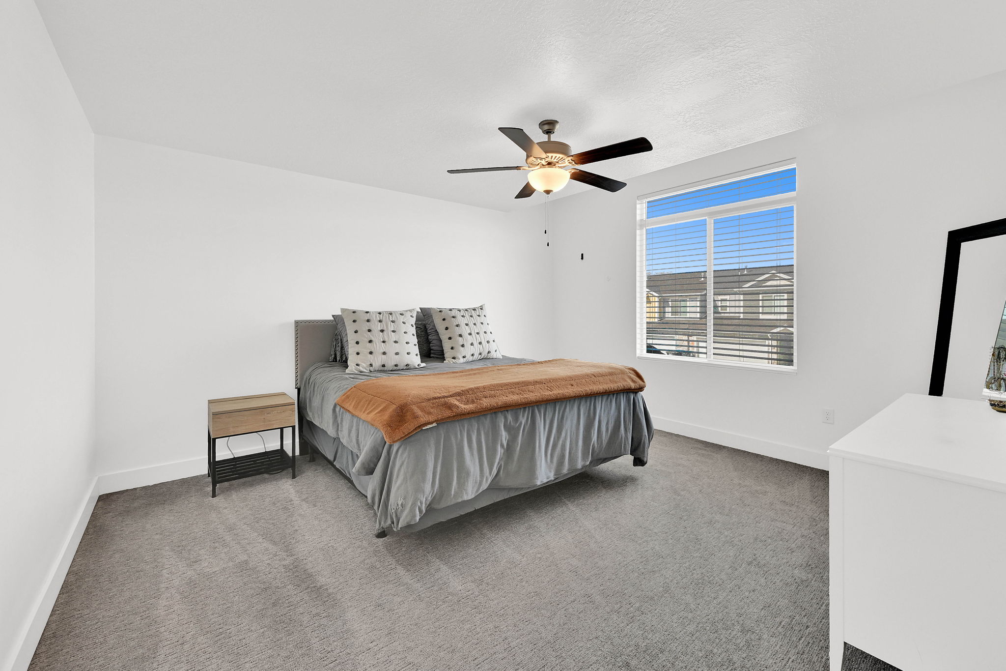 Bedroom with light colored carpet and a ceiling fan