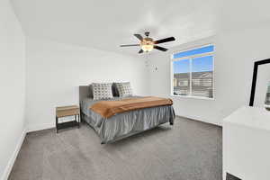 Bedroom with light colored carpet and a ceiling fan