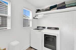 Laundry area featuring washer and dryer and light wood finished floors