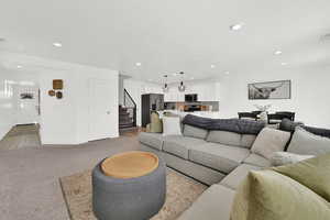 Living room with light colored carpet and recessed lighting