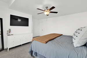 Carpeted bedroom with ceiling fan and a textured ceiling