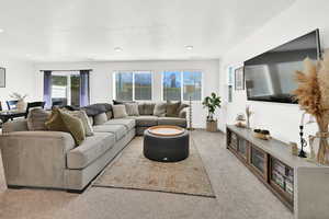 Living room with light colored carpet and a textured ceiling