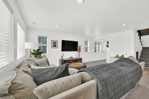 Living room with carpet flooring, recessed lighting, and a textured ceiling