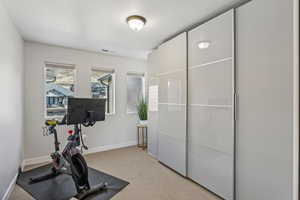 Exercise area featuring light colored carpet and baseboards