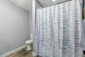 Bathroom featuring stone tile floors and a shower with curtain