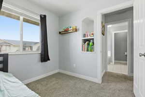 Bedroom with baseboards and light carpet