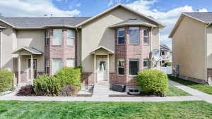 Traditional-style house with brick siding, stucco siding, and a front yard