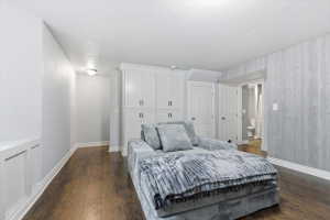 Bedroom featuring dark wood-style flooring, a textured ceiling, and a closet