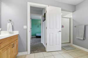 Bathroom with vanity, a stall shower, ensuite bath, and light tile patterned floors