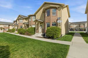 View of front of home featuring a front lawn, stucco siding, brick siding, and a residential view