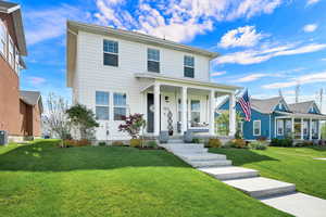 View of front of house featuring a front lawn and covered porch