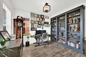 Home office featuring built in features and dark wood-style flooring