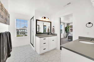 Bathroom featuring two vanities, connected bathroom, and a shower stall