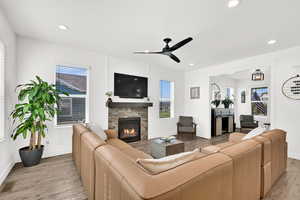 Living area featuring a fireplace, light wood finished floors, a ceiling fan, and recessed lighting