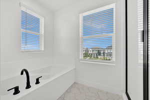 Full bathroom featuring baseboards and a garden tub