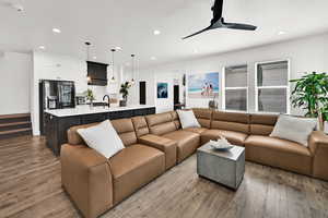 Living room with light wood-style floors, a ceiling fan, and recessed lighting
