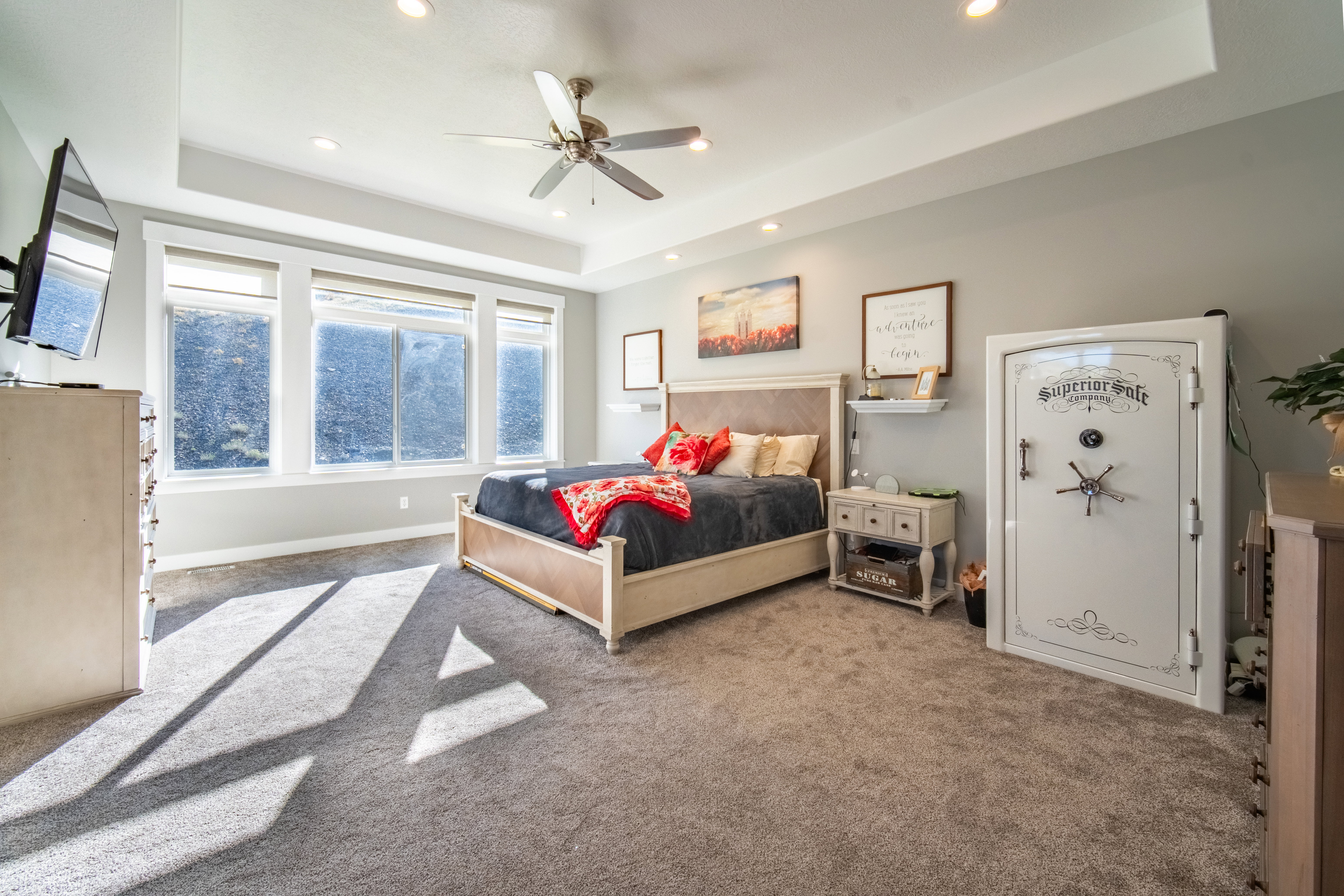 Primary bedroom featuring a tray ceiling, ceiling fan, and recessed lighting
