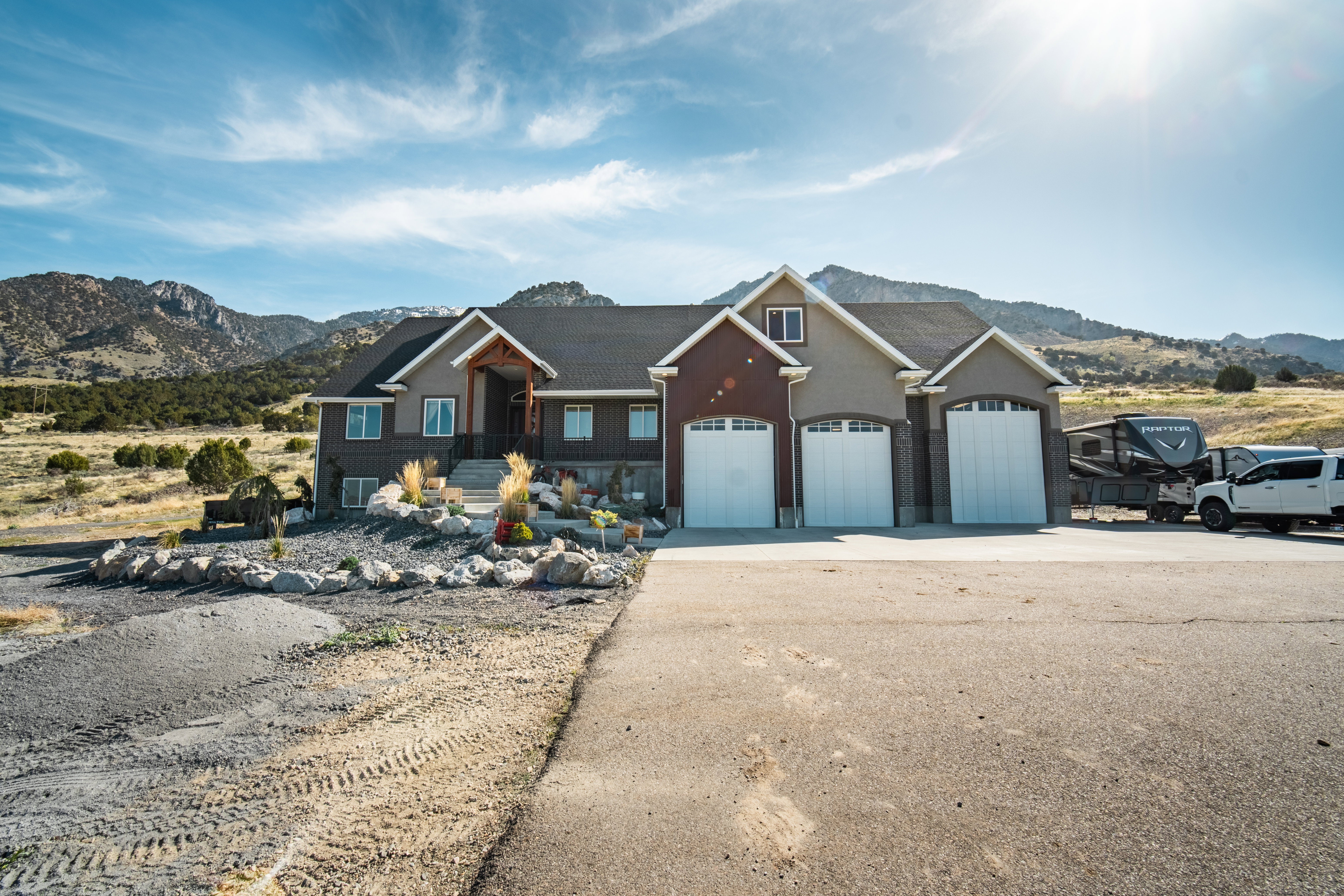 View of front of home featuring a mountain view, driveway, an attached garage, and stucco siding