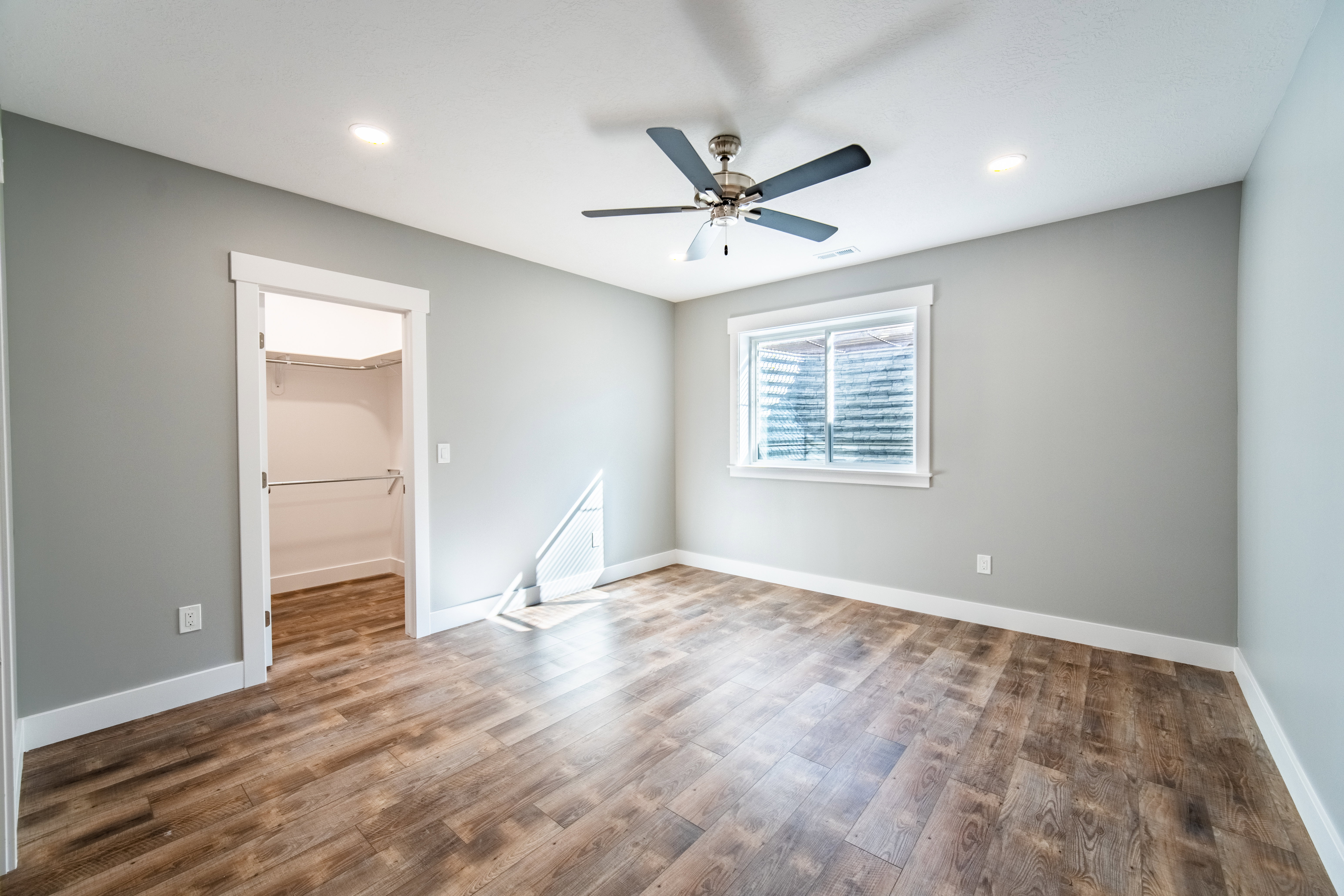 EnSuite bedroom with wood finished floors, ceiling fan, and recessed lighting