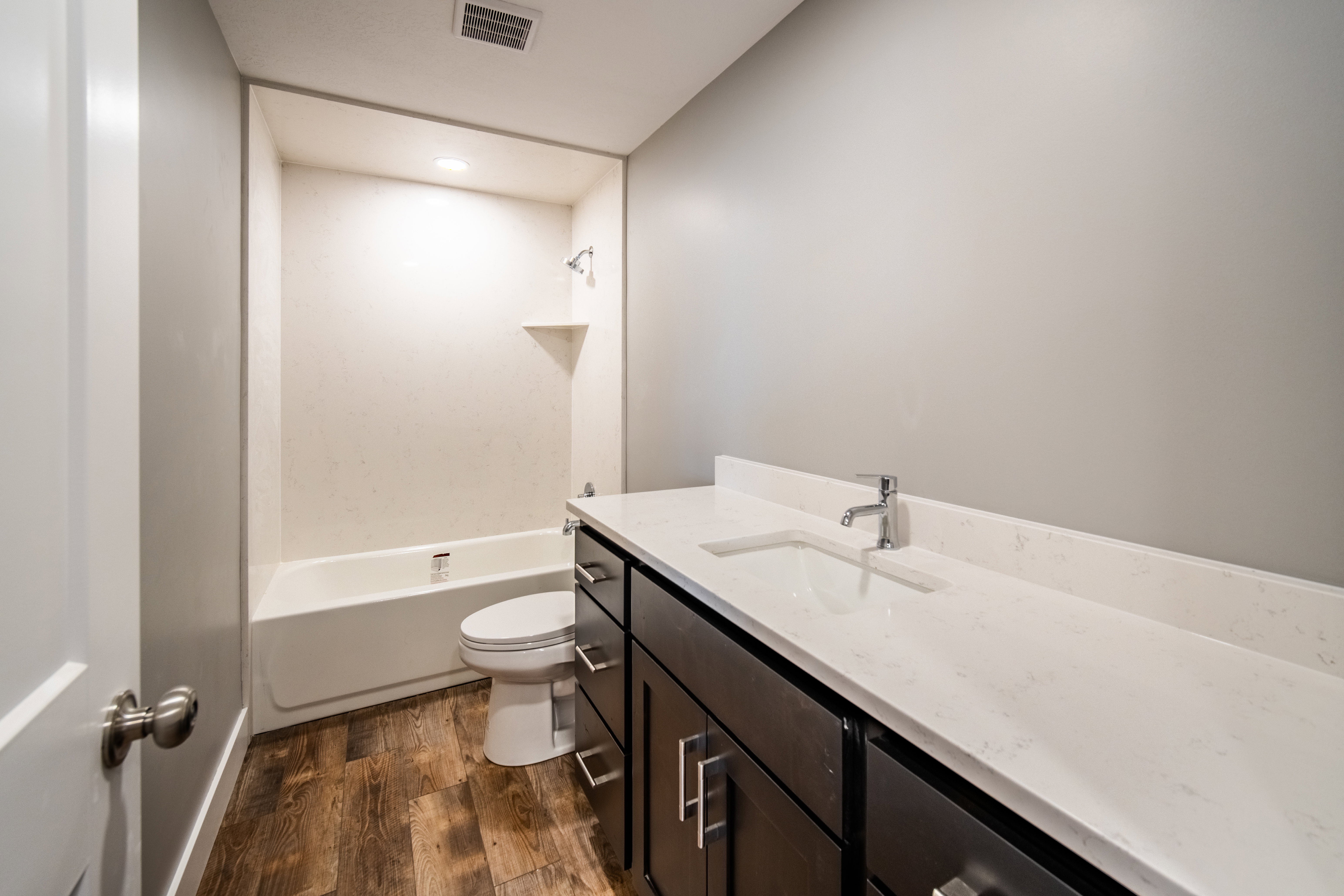 Full bathroom with vanity, wood-type flooring, bathing tub / shower combination, and recessed lighting