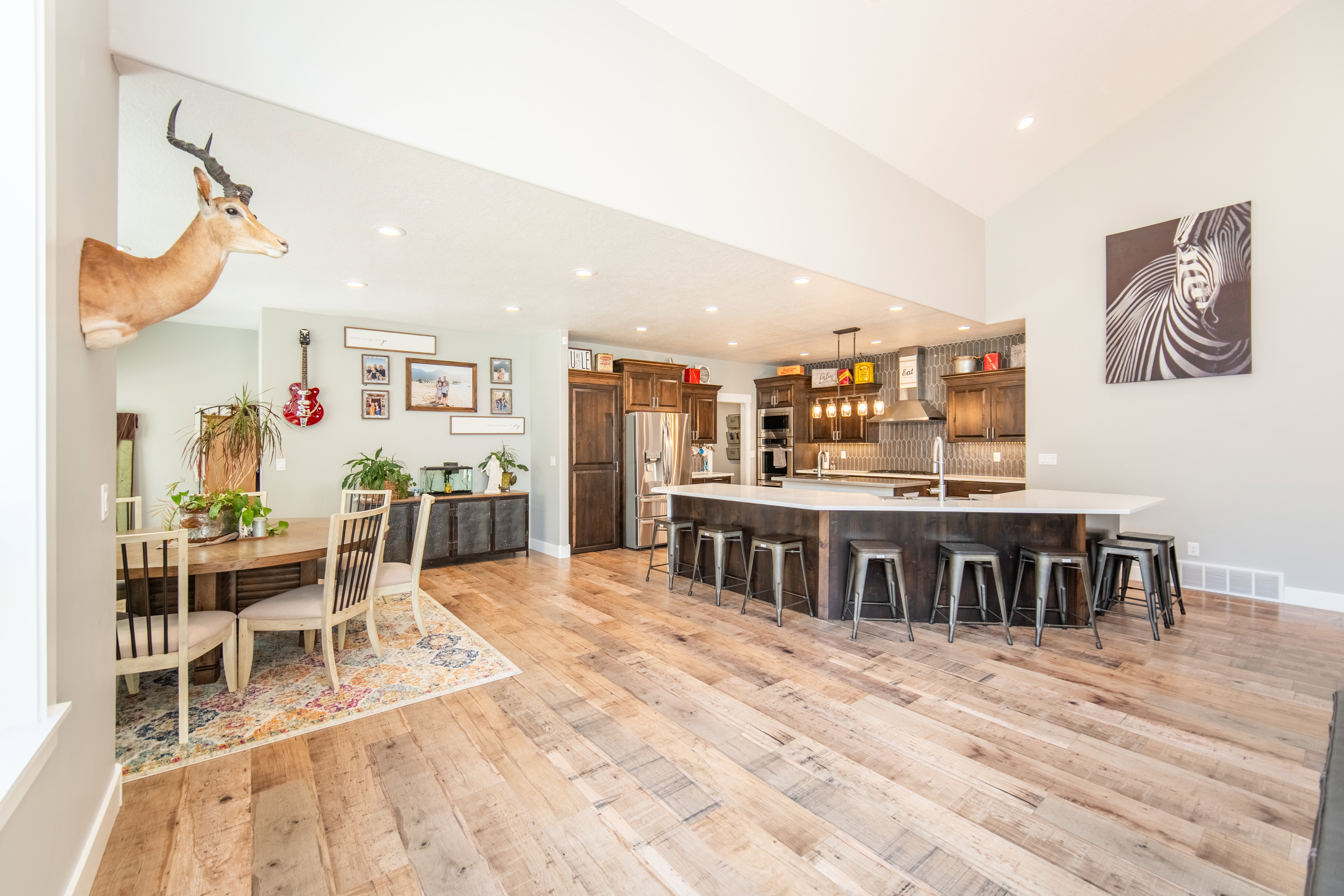 Kitchen with a kitchen breakfast bar, wood finished floors, backsplash, and pendant lighting