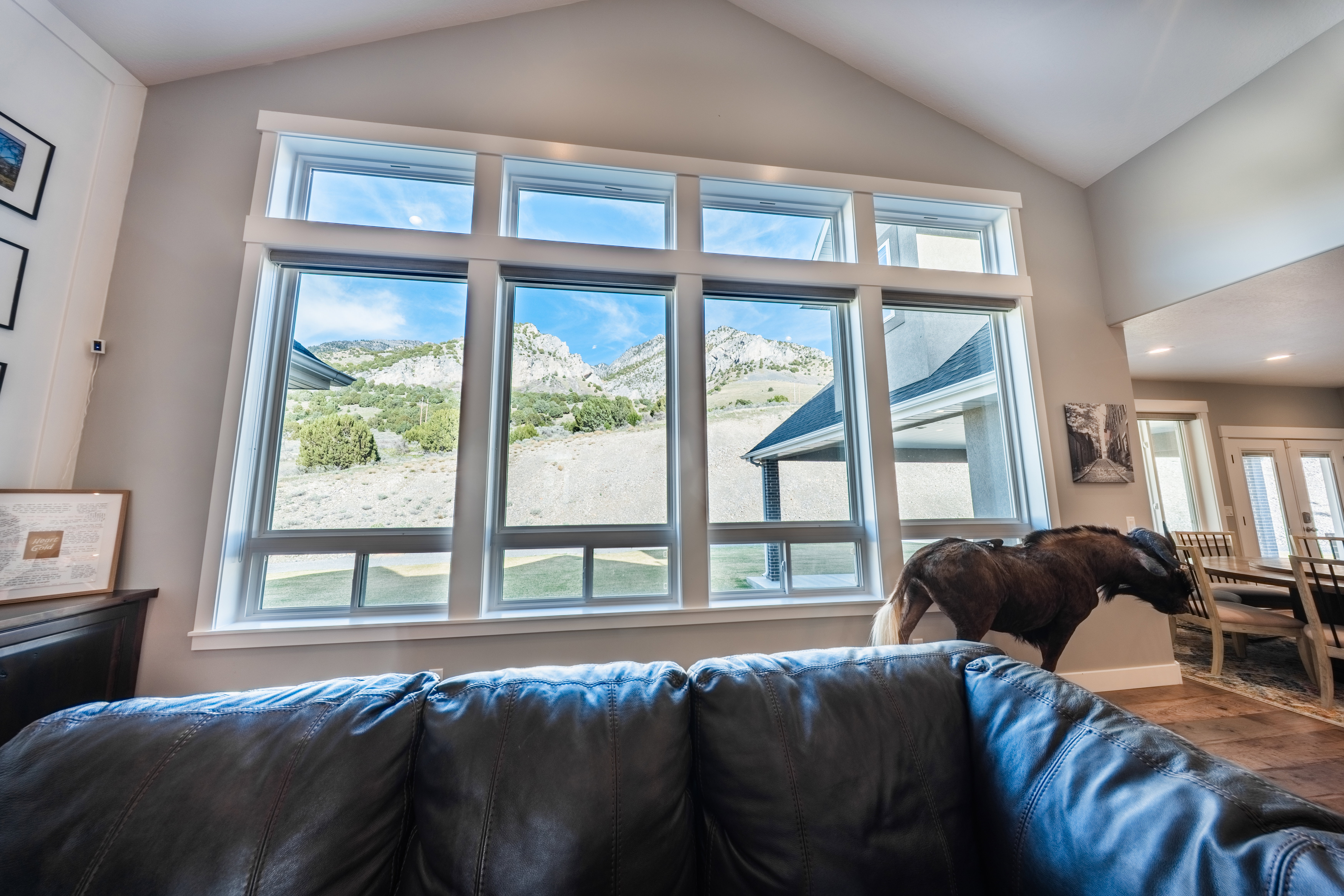 Living area featuring vaulted ceiling, plenty of natural light, mountain views, and wood finished floors