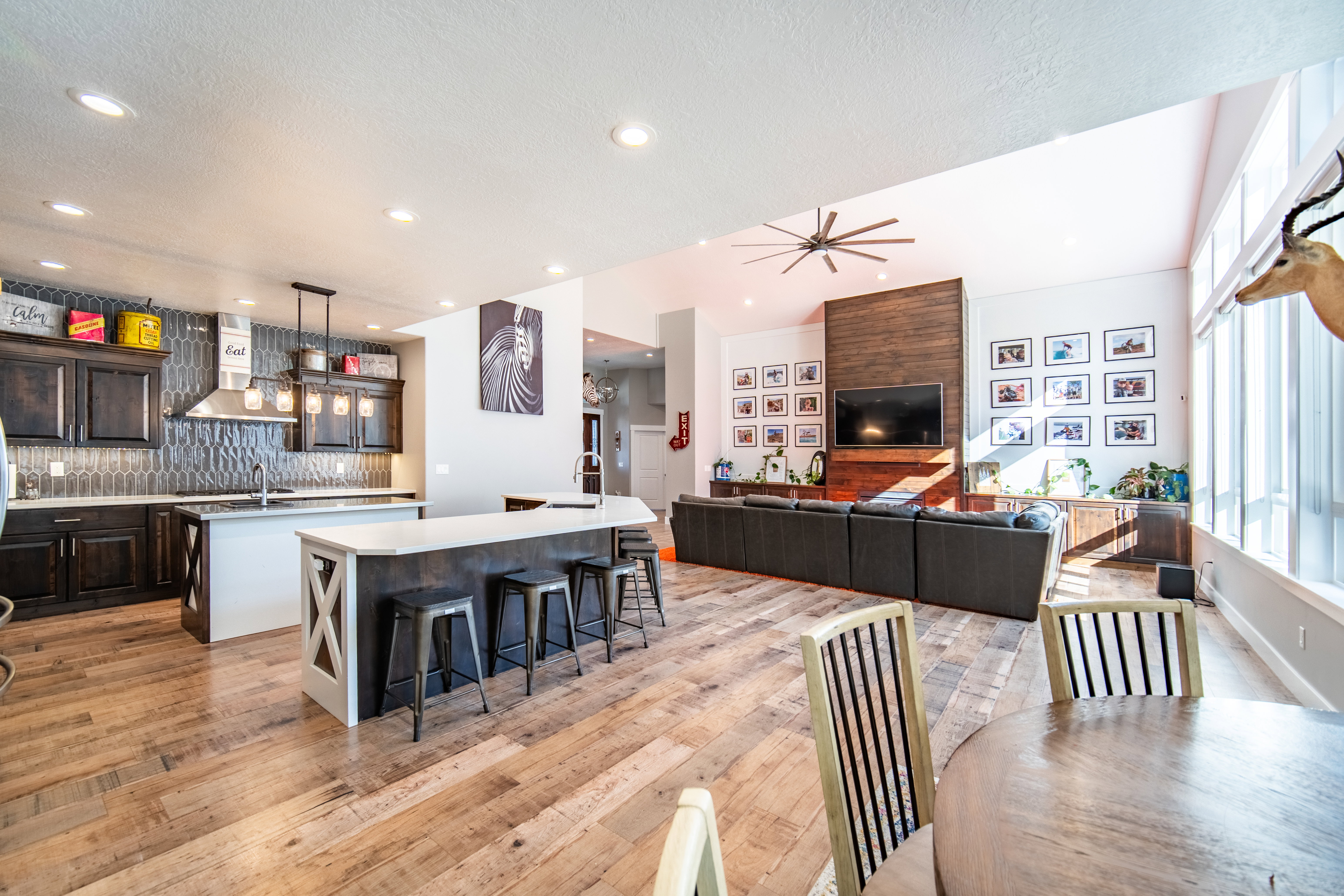 Kitchen featuring open floor plan, dark wood finish cabinetry, backsplash, a kitchen breakfast bar, prep island and wood finished floors