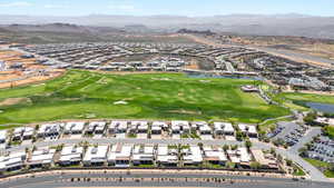 Aerial view of residential area featuring a golf course and a water and mountain view