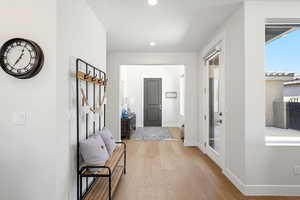Entrance foyer with light wood-style floors and recessed lighting