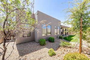 View of side of home with stucco siding and a patio