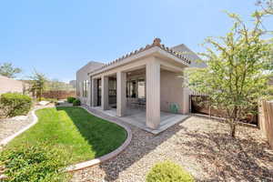 Back of property with a fenced backyard, a patio area, stucco siding, and a tiled roof