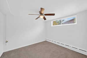 Unfurnished room with a baseboard heating unit, carpet floors, and ceiling fan