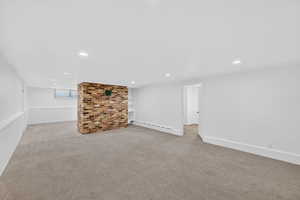 Below grade area with light colored carpet, recessed lighting, and a baseboard radiator