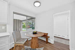 Dining room featuring breakfast area, wood finished floors, and a baseboard heating unit