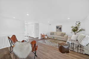 Living area featuring wood finished floors, recessed lighting, and a baseboard radiator