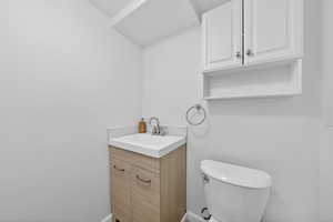 Half bathroom with vanity and toilet
