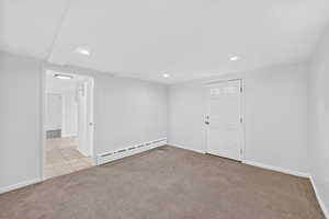 Unfurnished room with light carpet, baseboard heating, and recessed lighting
