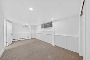 Below grade area featuring wainscoting, recessed lighting, carpet flooring, and a baseboard radiator